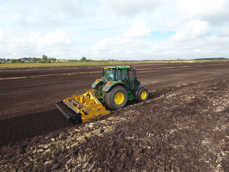 3m Alpego IZ Inversa Stone Burier working behind a John Deere tractor, drone view